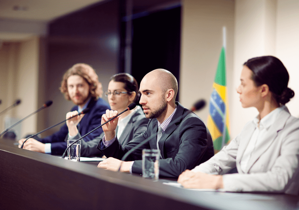 grupo de pessoas em uma sessão plenária usando microfone promic