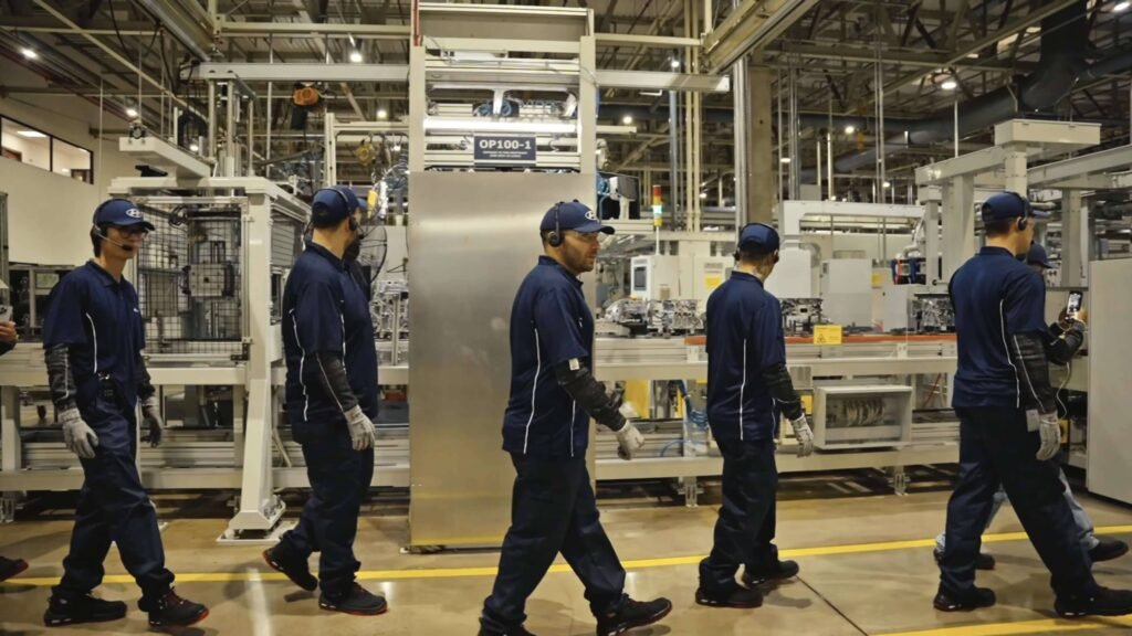 Grupo em uma das visitas guiadas na fábrica da Hyundai caminha pela produção usando headsets e radiocomunicadores da Riole.