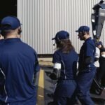 Grupo em visita na fábrica caminha pela área externa usando headset HE2B e transceptor DGVA WalkMeet, da Riole.